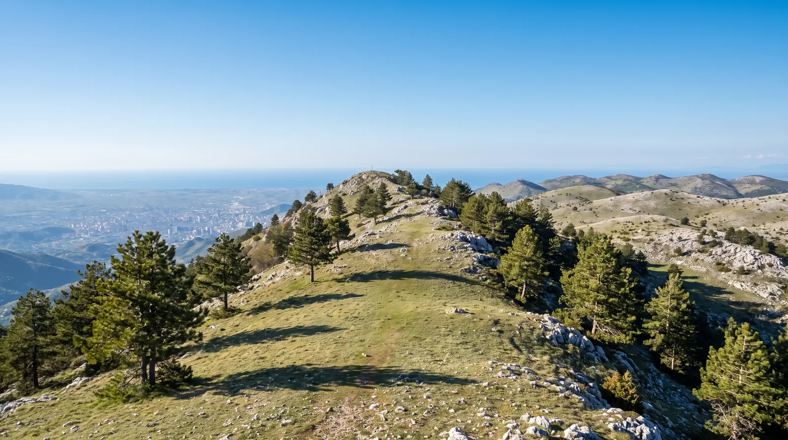 The summit ridge of Dajti with the Tirana plain hazy far below it