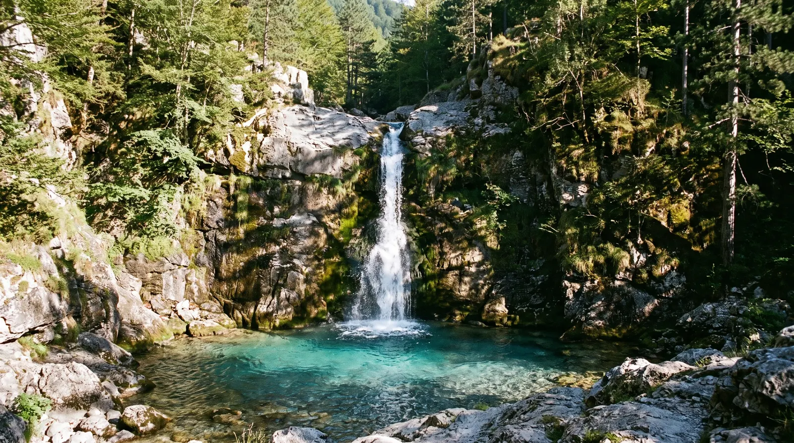The Grunas fall dropping over a limestone lip into its plunge pool below Theth