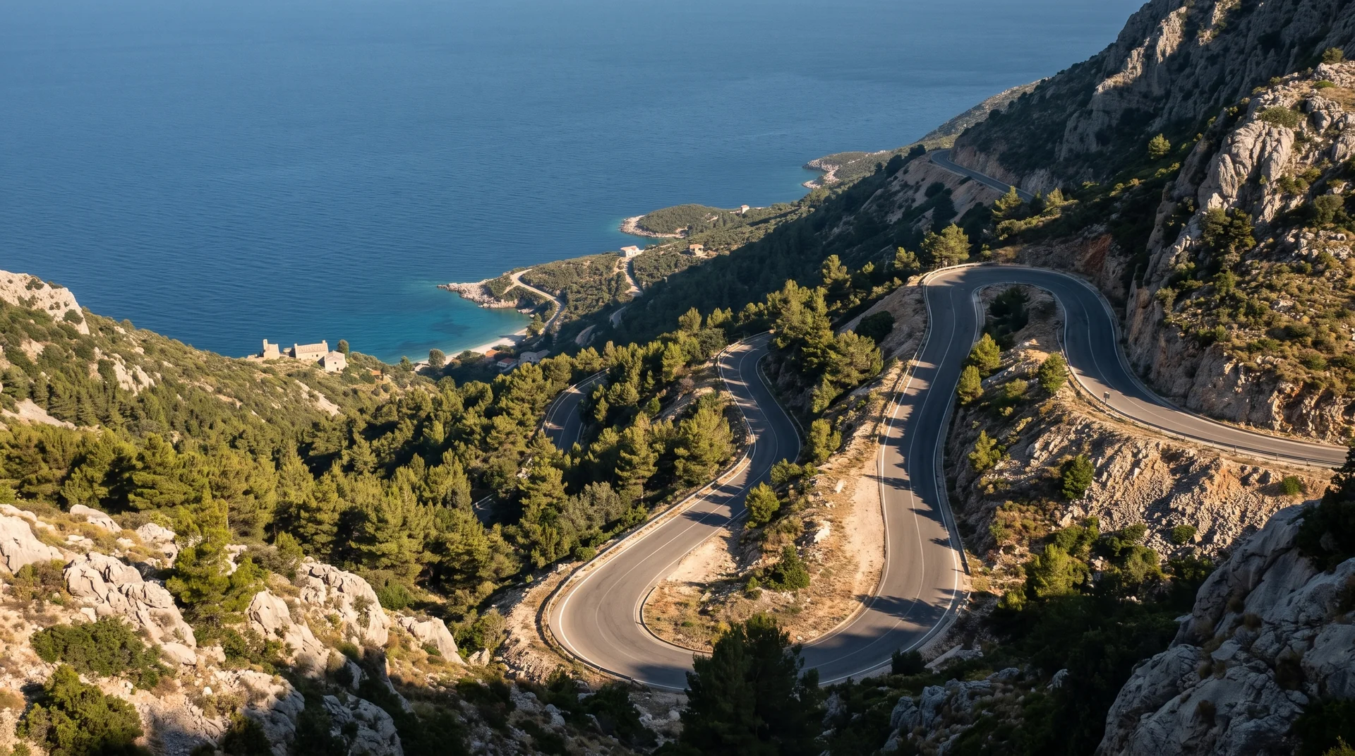 The SH8 switchbacks descending from the Llogara pass through pines to the coast far below