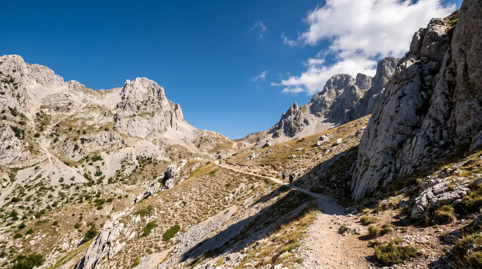 The worn path climbing open ground below the 1,795 m pass between the Valbone and Theth valleys